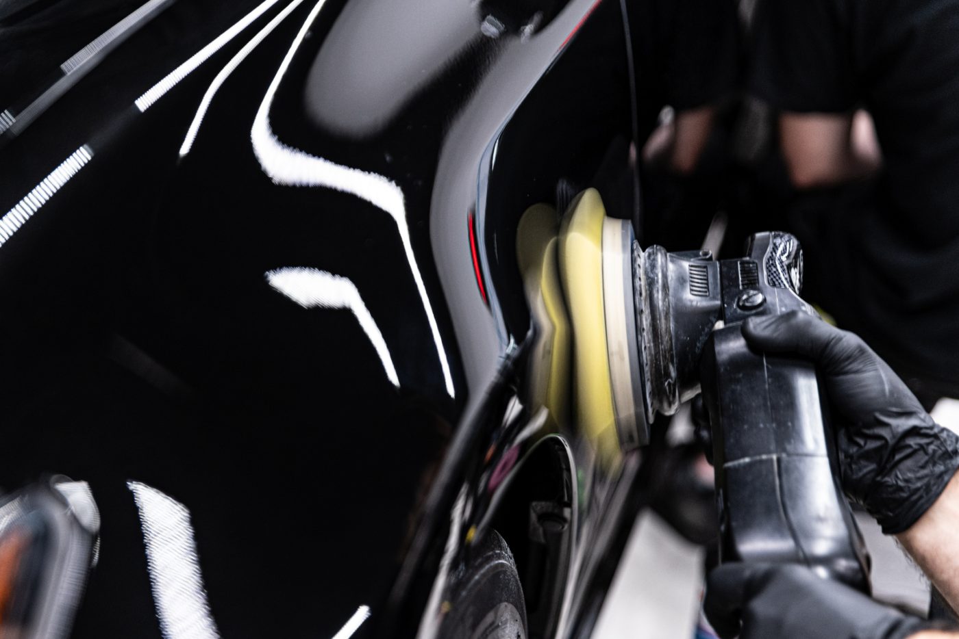 Mechanic inspecting brake disc and caliper on vehicle wheel during maintenance