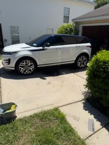 White and black convertible Range Rover parked in residential driveway