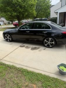 Black sedan parked in residential driveway on sunny day