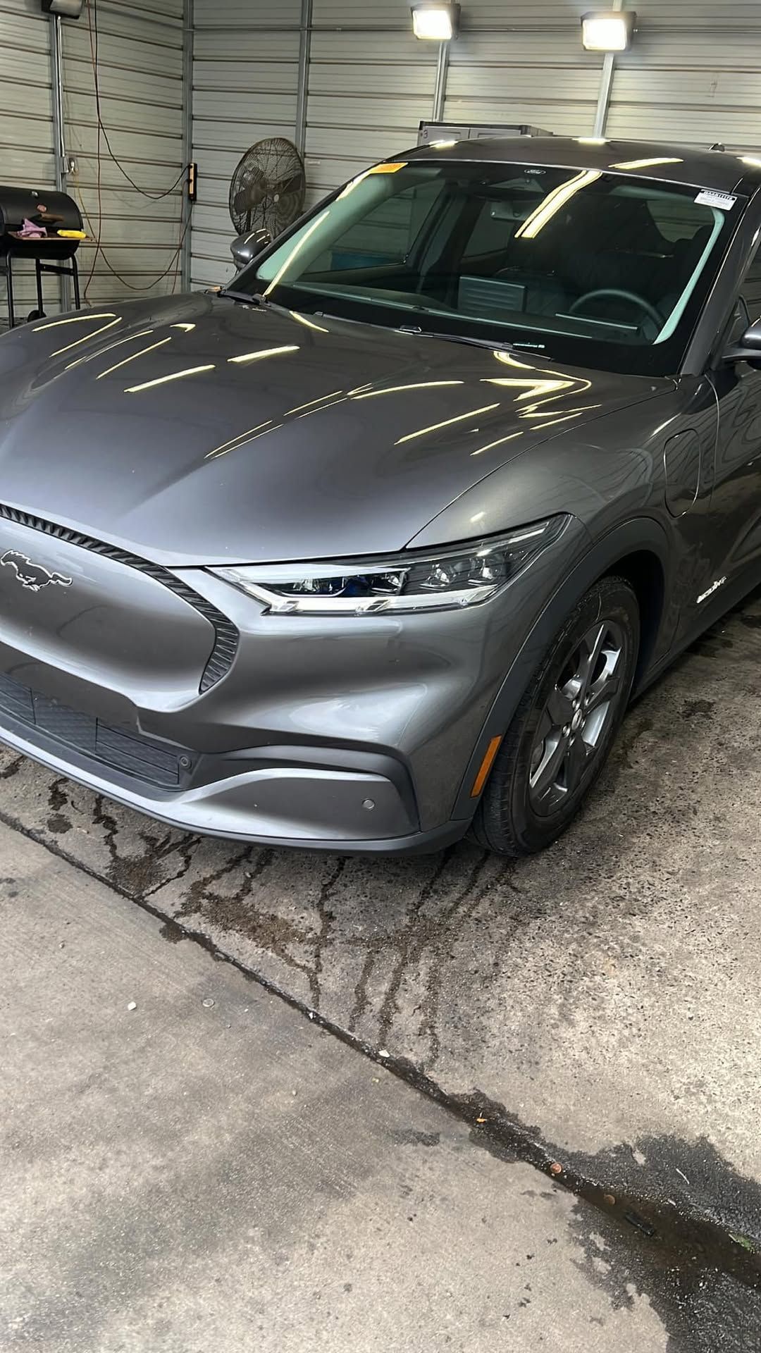 Silver Chevrolet electric vehicle in industrial garage with overhead lighting